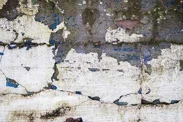 Destroyed shabby wall. Texture of cracked peeling plaster and paint. Facade of abandoned building.