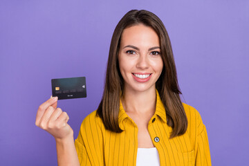 Photo of sweet millennial brunette lady hold card wear yellow shirt isolated on purple background