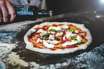 Fototapeten pizzabäcker bereitet rohen teig pizza olivenöl basilikum mozarella frische italienische napoletana napoli pizza kurz vor dem backen im ofen © Mateusz