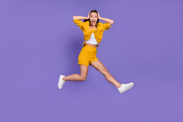 Fototapeta na wymiar Full length photo of crazy young lady run wear yellow suit sneakers isolated on violet background