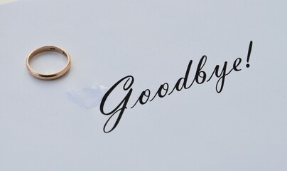 A break up. Parting. Message on paper about it and wedding ring.  Message on paper about parting.
