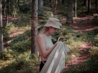 A girl in the woods holding her shirt in her hands