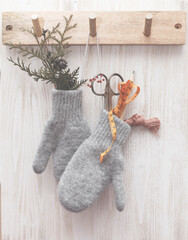 Wool mittens hanging with stitch tools. Christmas background.