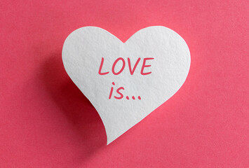 Obraz premium Paper heart with Love is written words on pink background