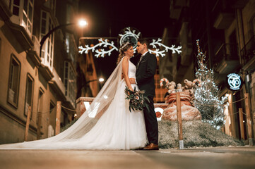 Couple on their wedding apparel against christmas street decoration
