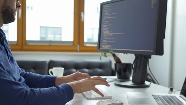 Computer programmer writing code working from home office