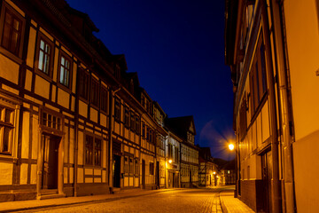 Nachtaufnahme einer Straße mit Fachwerkhäusern ohne Autos in Stolberg im Harz