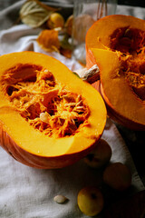 There is a layout of pumpkin and autumn leaves on the kitchen table 