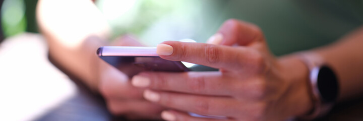 Woman holding modern smartphone in hands closeup