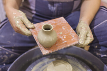 Pottery artist showing clay vase in ceramic studio. Creative handmade craft.