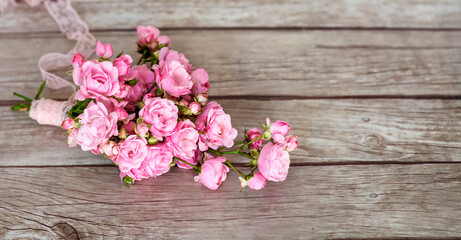 Fototapeta na wymiar Beautiful Pink Roses Bouquet on a Wooden Background .Home Decoration Elements 