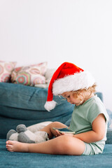 Little girl wearing Santa hat using smartphone