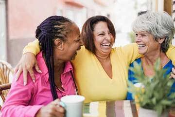 Multiracial senior friends meet and chat at bar outdoor while drinking coffee together at bar...