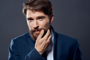 bearded man jacket with tie dark background