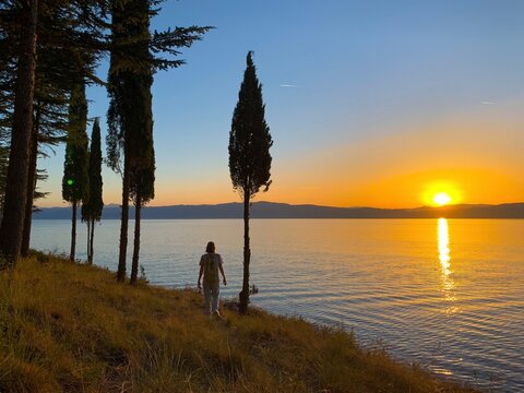 Idyllic Orange Sunset At The Lake, Silhouette Of The Mountains Background