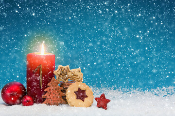 First Advent candle with golden decoration and christmas cookies.