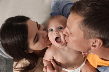 Happy family with their cute baby indoors, above view