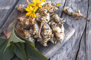 Raw jerusalem artichoke. Topinambur vegetable root on wooden table.