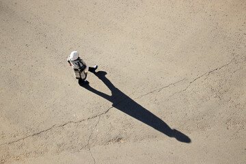 Woman crossing the street, top view, long shadow on asphalt. Concept of road safety