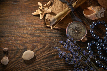 A marine concept with a bottle, starfish, seashells, rope, compass and paper scroll, pirate still life