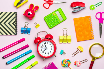 Frame from school and office supplies Paper clips, scissors, pens, felt-tip pens, sharpener, calculator, stapler isolated on pink background Flat lay Top view Back to school, education concept