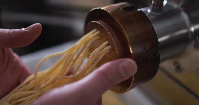 Man working with pasta manufacture machine - Fresh food and pasta factory concept