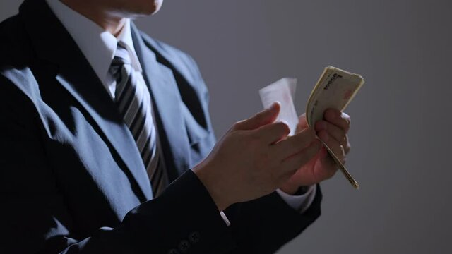 お札を数える中年ビジネスマン（ビジネス・金融）