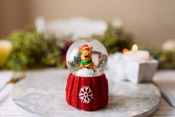 Snow globe on the plate at the christmas table