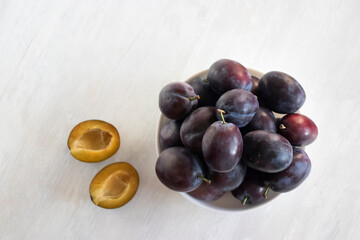 Ripe plums in a white plate.