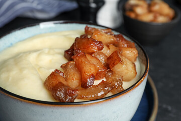 Potato puree and tasty fried cracklings on table, closeup. Cooked pork lard