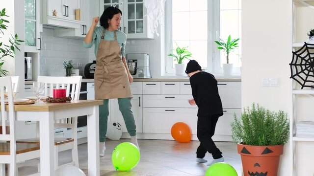 Mom And Son In A Skeleton Costume Have Fun Dancing On A Halloween Holiday At Home In The Kitchen