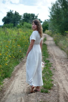 Outdoor photos of young woman in her 30's. Summer season in Poland. Woman on dirt road.