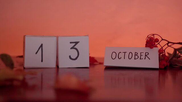 Cube calendar with an important date of October 13th with maple leaves and berries on the desk. Autumn Season. International Day for Natural Disaster Reduction
