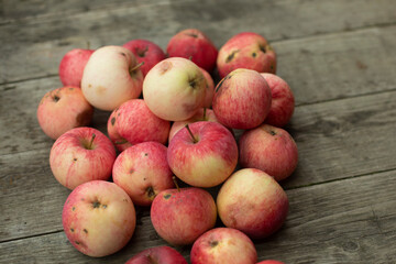 Red apples in autumn. Juicy fruit lies on the boards.