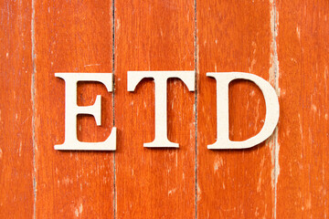 Alphabet letter in word ETD (abbreviation of estimated time of departure or the estimated time of delivery) on old red color wood plate background