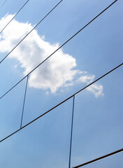  a white cloud is reflected in a metal facade 