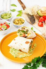 Three sauce burrito. Yellow plate, white background.