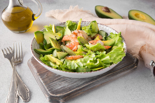 shrimp and avocado salad in a ceramic plate on a light table