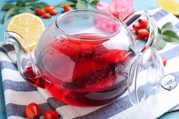 Fresh rose hip tea and berries on table, closeup