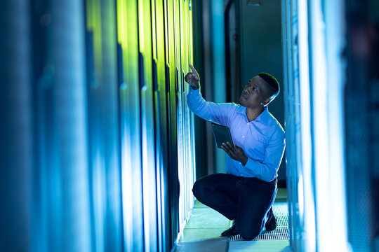 African american male computer technician using tablet working in server room