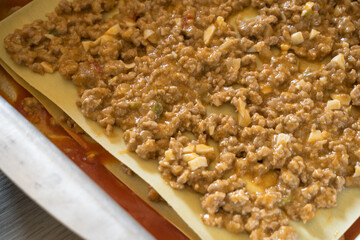 tray with plates and meat filling to make lasagna. Step by Step