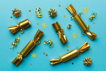 Christmas crackers with shiny confetti on color background, top view, copy space