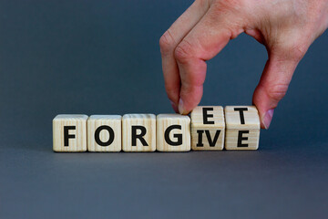 Forgive and forget symbol. Businessman turns wooden cubes and changes the word 'forgive' to 'forget'. Beautiful grey background, copy space. Business, psychological forgive and forget concept.