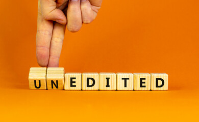 Edited or unedited symbol. Businessman turns wooden cubes and changes the word unedited to edited. Business and edited or unedited concept. Beautiful orange background, copy space.