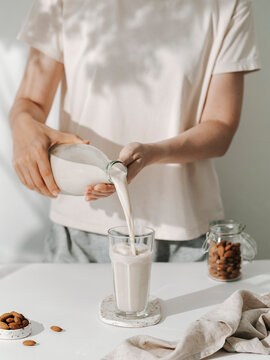 Woman pouring almond vegan milk
