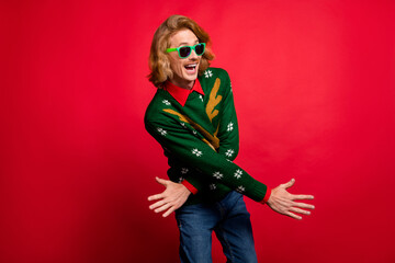 Photo of funky charming young man wear green sweater spectacles smiling dancing isolated red color...