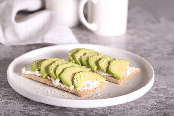 an appetizer of cottage cheese avocado and bread lies on a white plate