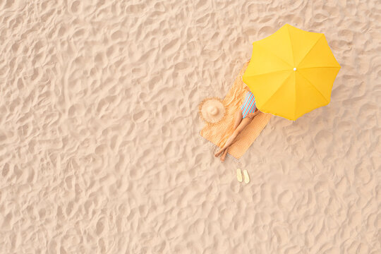 Woman Resting Under Yellow Beach Umbrella At Sandy Coast, Aerial View. Space For Text