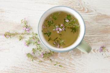 mug with thyme tea on a light table