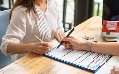 Customers interested in buying a home sign a signature to enter into a home purchase contract with...